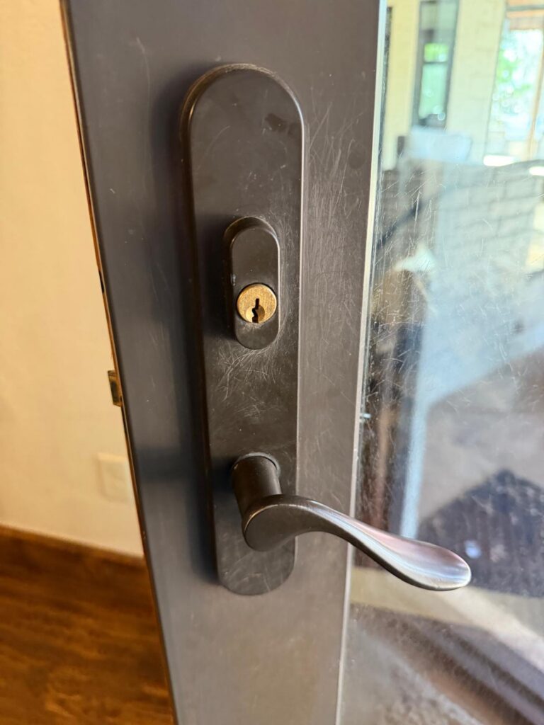 Bronze lever handle with keyed lock cylinder on a glass patio door in Edmond, OK