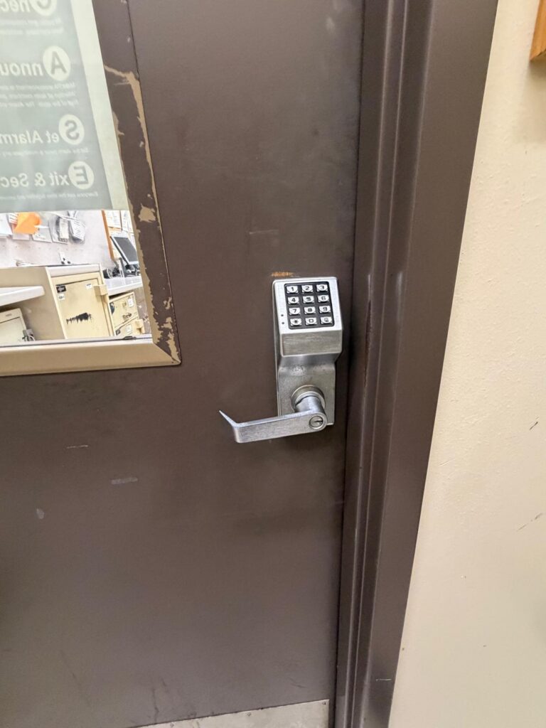 Stainless steel push-button keypad lever lock with key override on a commercial steel door in Oklahoma City