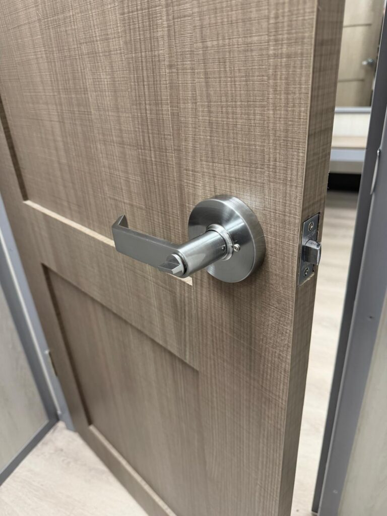 Newly installed satin chrome privacy lever lock on a wood-grain office door in Edmond, OK