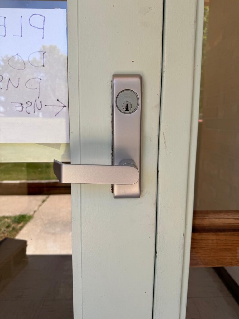 Aluminum storefront door with exit device lever trim and keyed cylinder in Edmond, OK